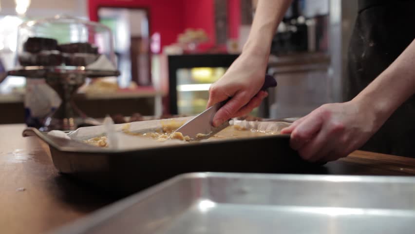 A baker cutting into a cake.