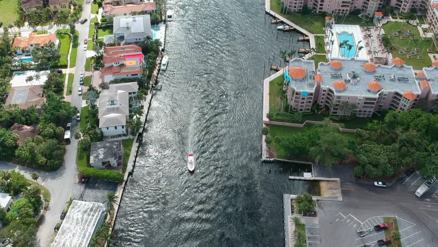 Drone shot down the many waterways in Boca Raton, Florida with luxury homes on either side.