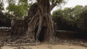 Hand held shot going through temple's gate with roots and ruins at Ta Som Temple Angkor Wat, Siem Reap Province, Cambodia 