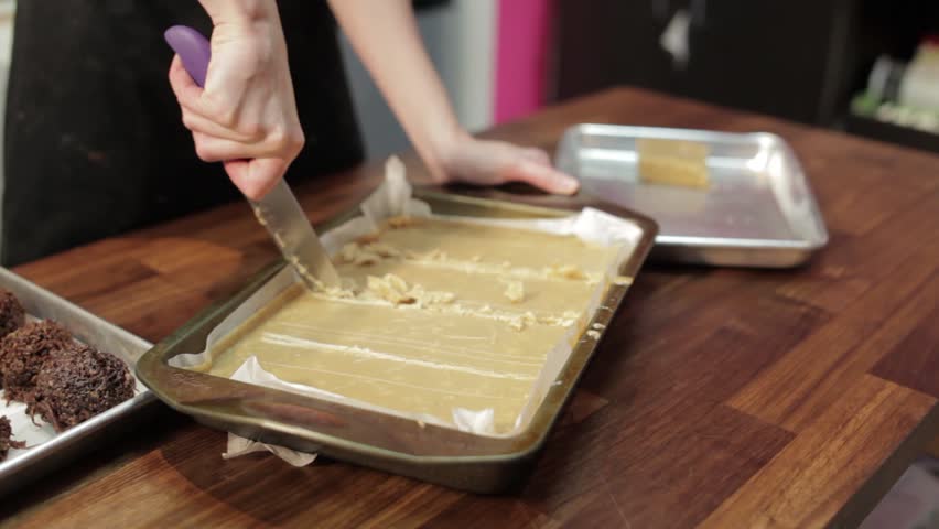 A bakery and pastry shop preparing a cake. Cutting into a cake.