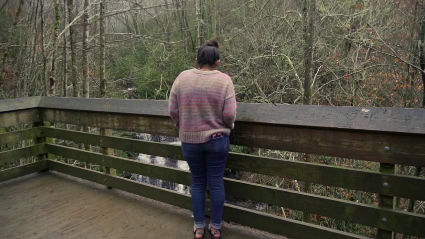 A Woman looks at the waterfall in awe.
