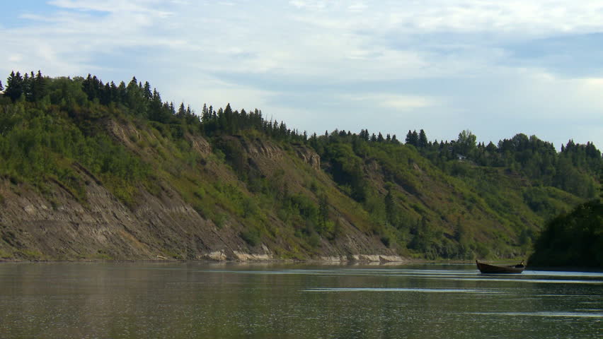 Wooden boat sits anchored in the North Saskatchewan River. Edmonton, Alberta, Canada.