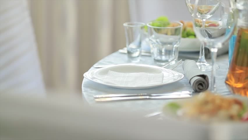 waiter brings dish with salad in restaurant puts plate on covered with white tablecloth, cutlery and dishes are on table in cafe Caesar salad is served on table. Royalty-Free Stock Footage #1015987072