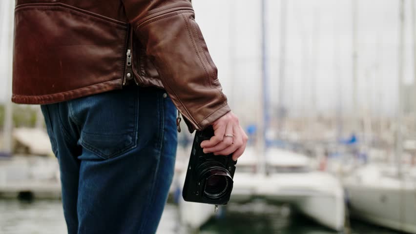 Handsome young male photographer taking photograph with professional photo camera
