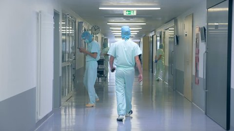 Back view of a male doctor walking along the hospital corridor