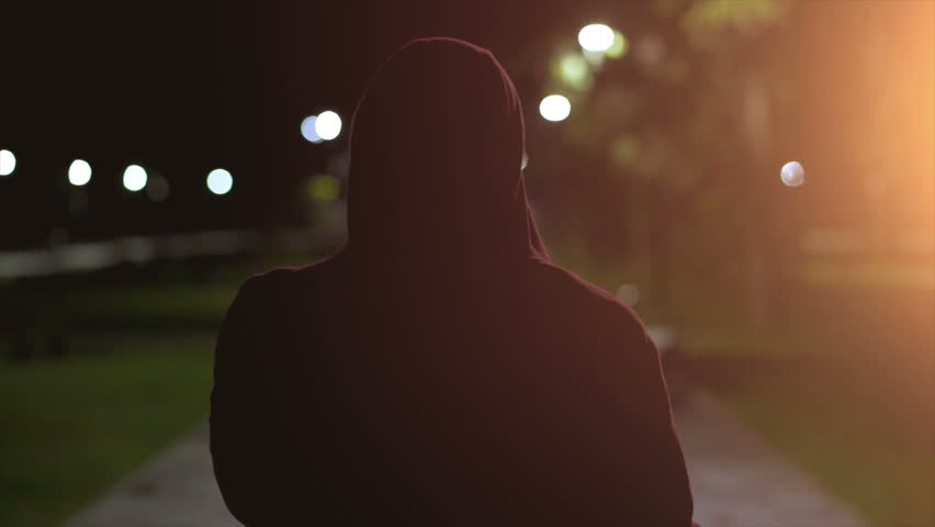The fellow in a hood walking and smoking on the night street. slow motion | Shutterstock HD Video #1015999861