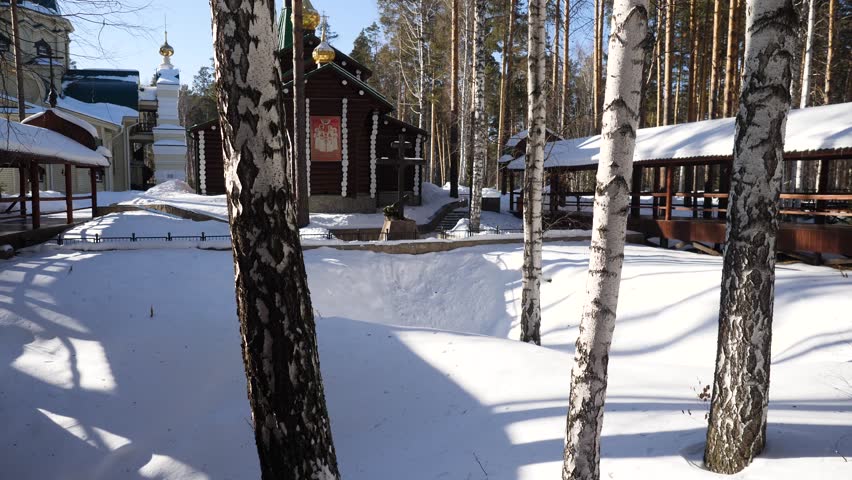 Old church tilt with white trees in the forest in winter