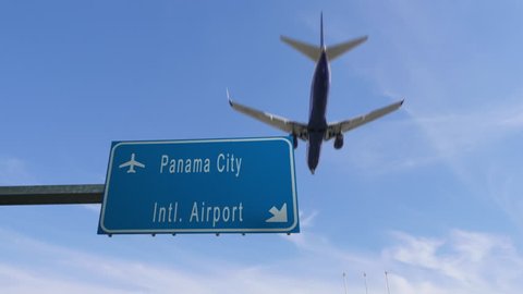panama city airport sign airplane passing overhead