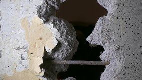 Ungraded: Worker expands hole in the wall, knocking out fragments of concrete with a hammer drill. Ungraded H.264 from camera without re-encoding.