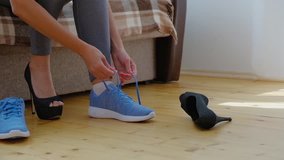 Woman changing high heels shoes before training, slow motion video