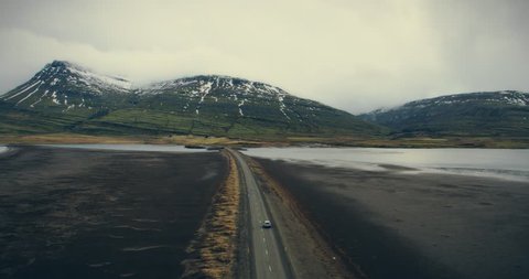 Aerial view an endless road through volcanic land, filmed by drone, Iceland