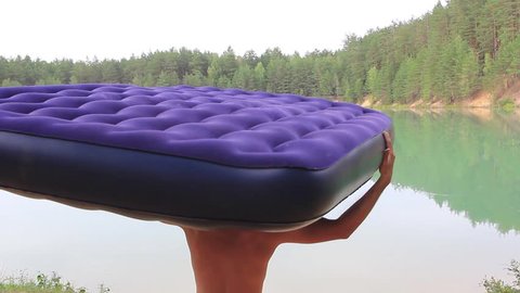 the guy is on vacation on a mattress on the lake