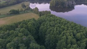 4K. Aerial view Lake with a green island. Sunset sunset view from the air to a beautiful island with large trees. Place location Poland.