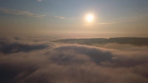 Aerial View of Flying Over Clouds at Sunrise