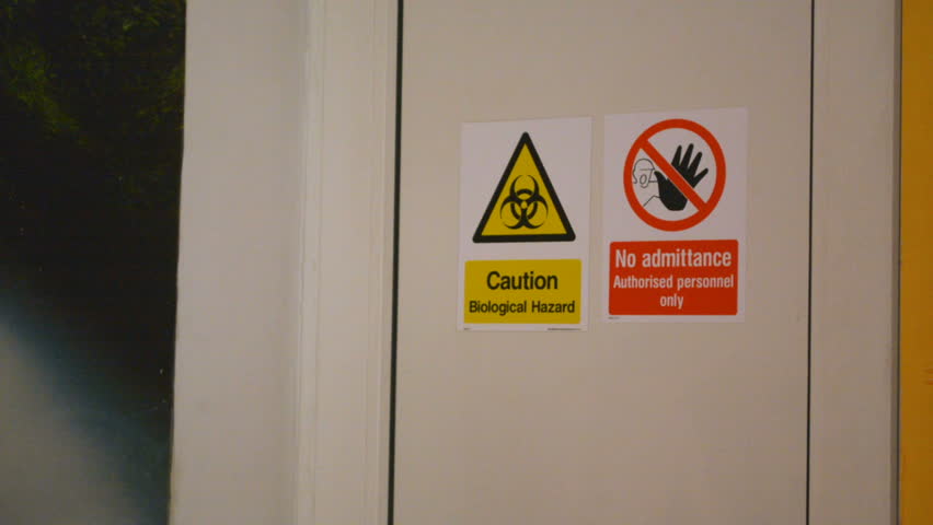 Zoom in on Caution Biological Hazard and No Admittance warning danger signs on the door Royalty-Free Stock Footage #1016040007