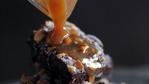 Brownie with nuts. Pouring caramel syrup. 4k