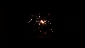 Slow motion video. Sparkling burning Bengali Christmas fire on a black background. A holiday concept or an element of video design.