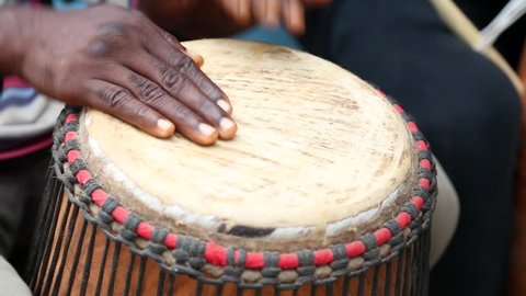 African Art. Men play handmade drums in an art market in West Africa.
