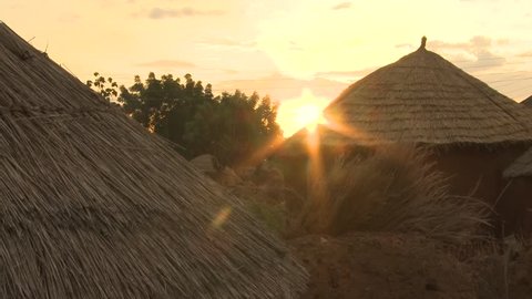 African village of huts and earth houses during sunset.