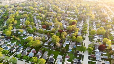 Aerial view of residential houses at spring (may). Establishing shot of american neighborhood, suburb.  Real estate, drone shots, sunset, sunlight, from above.
