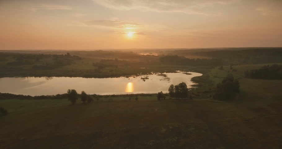 Sunset, aerial, atmospheric view on curving river.