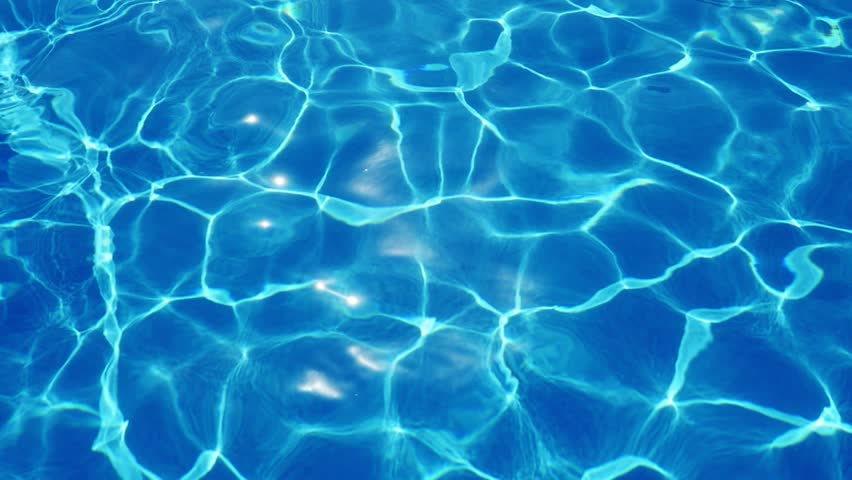 A magnificent view of swaying cyan blue waters in a pool with a sparkling and changing web shaping an arty aslant background.  Royalty-Free Stock Footage #1016052553