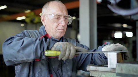 An elderly man in production. The worker will have a file. Stock-video