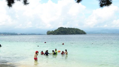 Sabah, Malaysia - 8 September 2018. Group of tourist having fun at Manukan island beach with taking pictures.