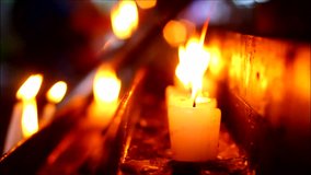 Close up video of prayer candles outside a chapel