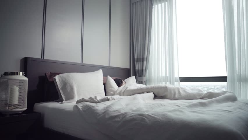 Woman waking up in white bed in bedroom Royalty-Free Stock Footage #1016077291