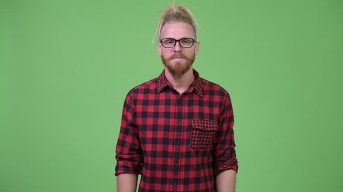 Handsome bearded hipster man with dreadlocks shrugging shoulders