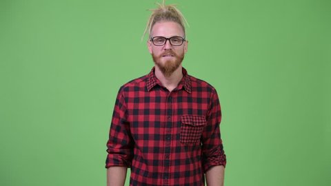 Handsome bearded hipster man with dreadlocks presenting something