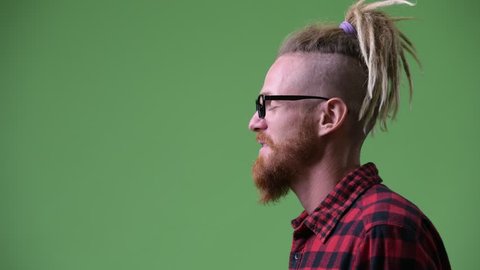 Profile view of happy handsome bearded hipster man with dreadlocks laughing