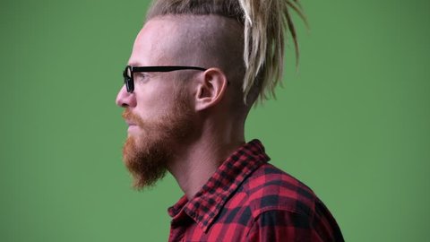 Profile view of handsome bearded hipster man with dreadlocks looking to camera