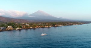 Aerial sunrise view of the beach Amed and volcano Agung, Bali. 4K
