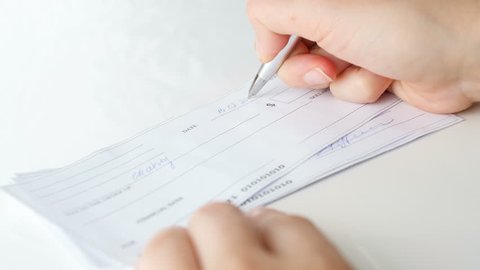 Closeup 4k footage of young woman signing 1000 dollars bank cheque with pen