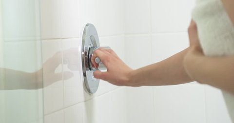 Woman turns on the shower.