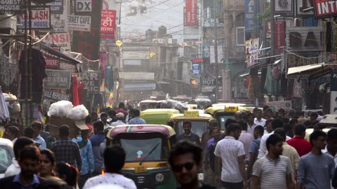 NEW DELHI, INDIA - SEP 8: Crowded street scene with pedestrians and auto rickshaw traffic on September 8, 2018 in New Delhi, India 