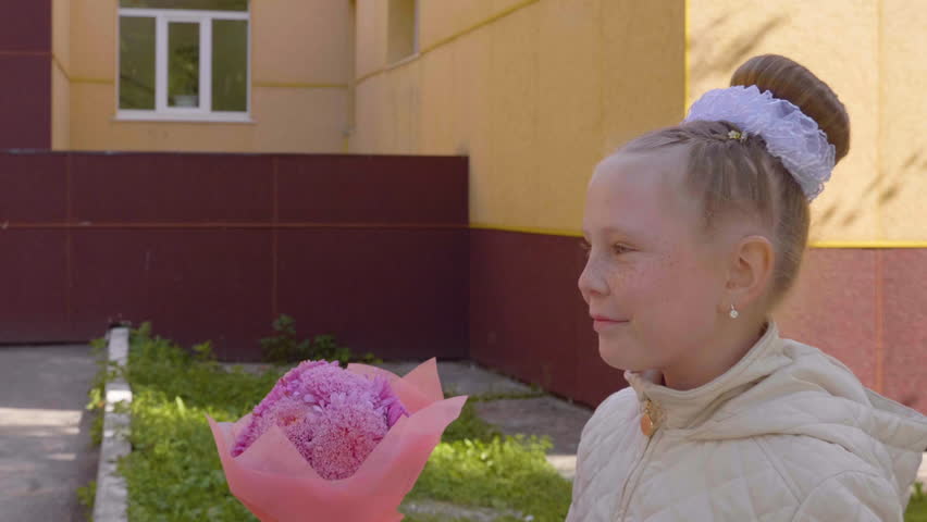Teenager girl with bouquet flower going to school. Back to school, autumn season