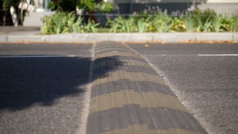 close-up, cars cross special restraint on the road, Traffic safety speed bump on an asphalt road,