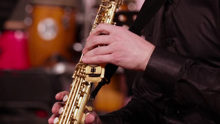 A man in a black shirt plays jazz music. Close-up of the hands of a saxophonist on a soprano saxophone. Royalty-Free Stock Footage #1016105242