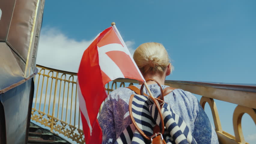A tourist with a backpack and the flag of Denmark rises up the famous spiral staircase of the Church of the Savior in Copenhagen, Denmark