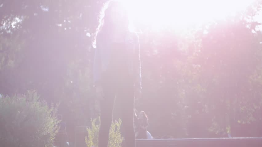 Young girl riding a gyro on the grass in the Park. Play of light. The glare of the sun.