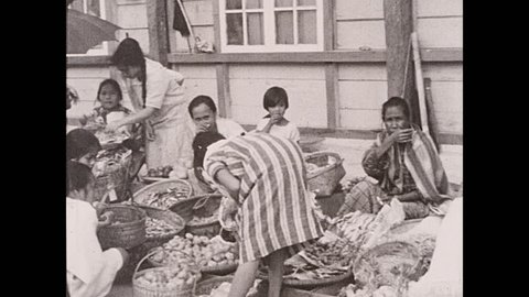 1930s: Philippines: women and children busy with chores in village. Igorottes people in village. Sellers at market in Baguio.