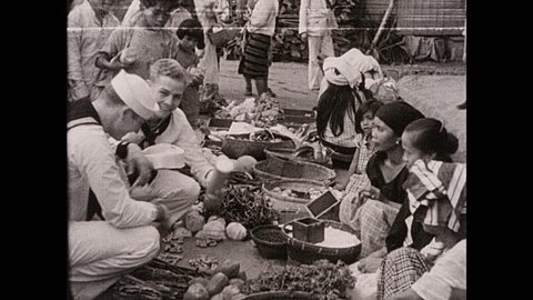 1930s: Philippines: sailors talk to sellers at fruit market in street. Lady gives fruit to sailor. Sailor picks fruit from market stall. Igarotte flappers in Baguio market.