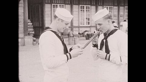 1930s: Philippines: sailors buy cigars in Baguio market. Sailor lights cigar