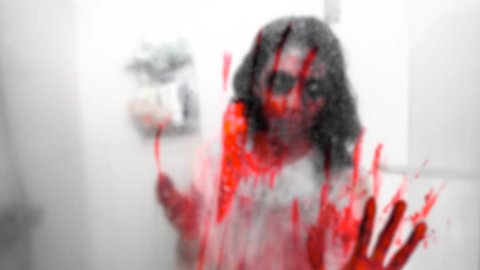 Scary zombie woman or ghost scratching mirror in the bathroom at home. Shot in 4k resolution