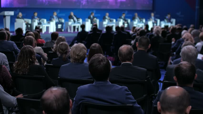 Audience in a conference hall listening to the speakers presentation on the stage. Business meeting concept. | Shutterstock HD Video #1016122885