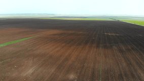 Tractor Ploughing Field Aerial Video. Tractor Plow Farm Field 4K Drone Flight. Cultivation Soil: Plowing Field Harvesting Aerial Top View Video. Fresh Ploughed Field 