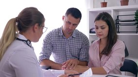 conversation about women health doctor giving negative news for young couple, man comforting his sad wife on reception in fertility clinic - Powered by Shutterstock - Get 15% off with code: PIKWIZARD15